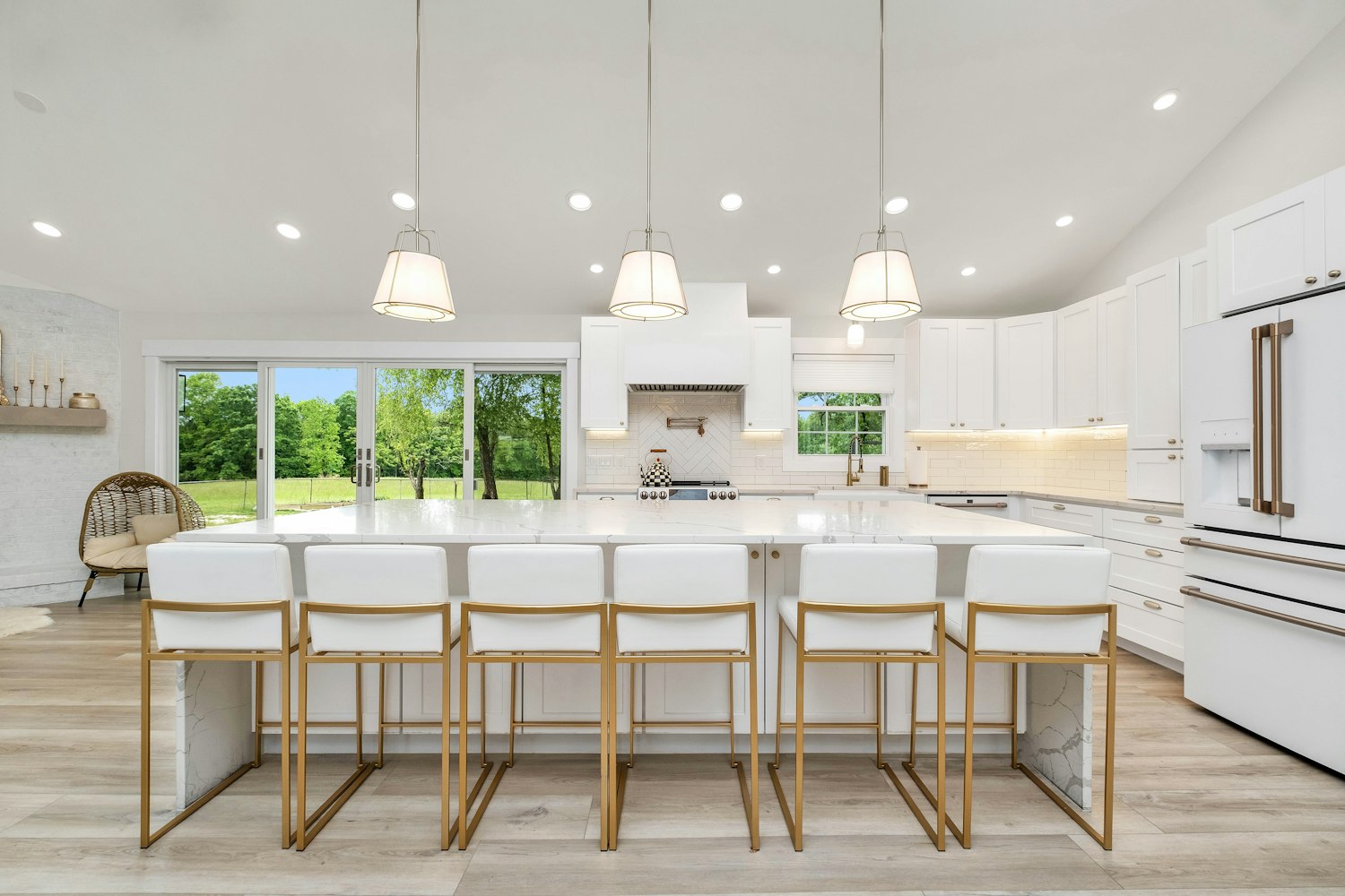 Modern kitchen with white cabinets, stainless appliances and pendant lighting